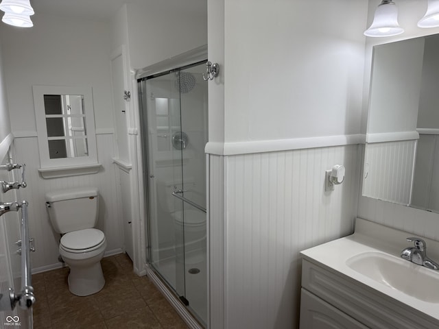 bathroom with vanity, tile patterned flooring, toilet, and walk in shower