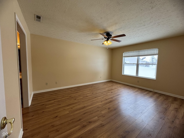 empty room with a textured ceiling, dark hardwood / wood-style floors, and ceiling fan