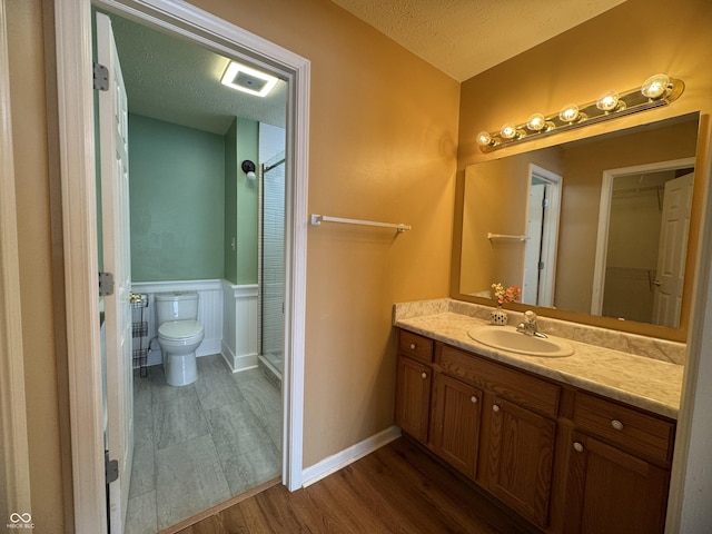 bathroom with vanity, wood-type flooring, a textured ceiling, and toilet