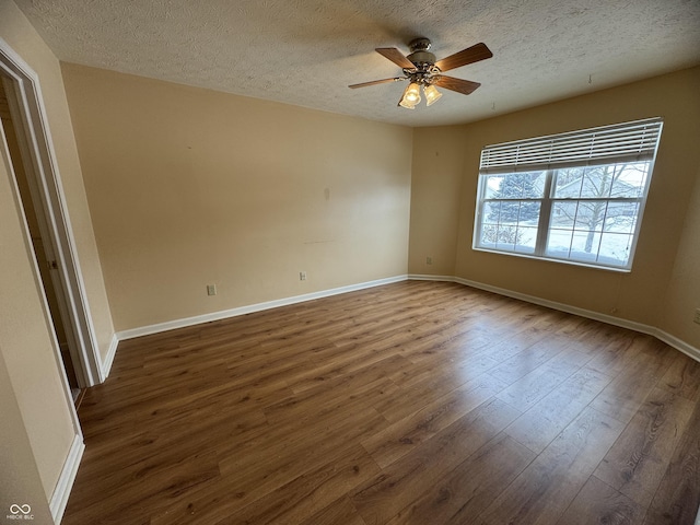 empty room featuring a textured ceiling, ceiling fan, and dark hardwood / wood-style floors