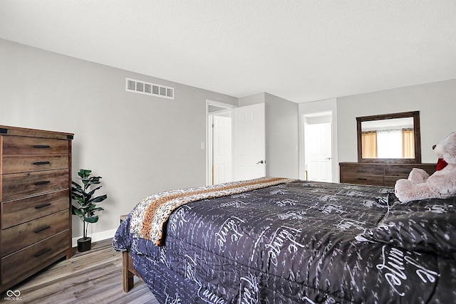 bedroom with wood-type flooring and a textured ceiling