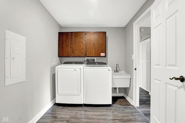 laundry area with cabinets, dark wood-type flooring, sink, independent washer and dryer, and electric panel