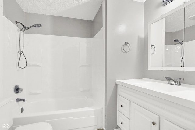 full bathroom featuring toilet, vanity, a textured ceiling, and bathtub / shower combination