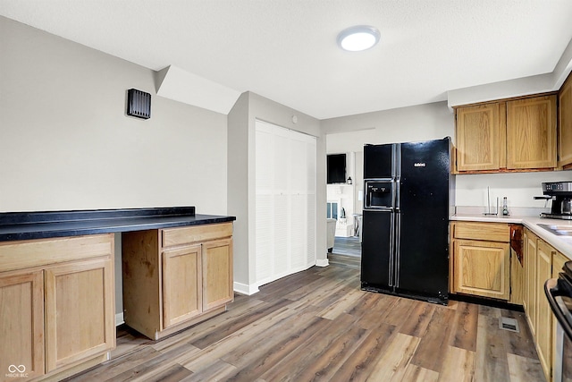 kitchen featuring black fridge, wood-type flooring, and range