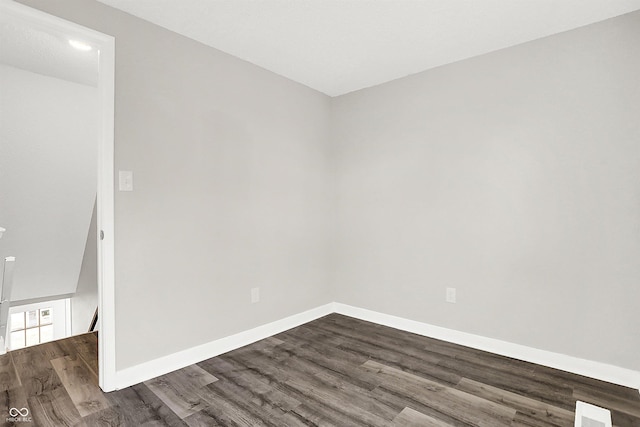 unfurnished room with dark wood-type flooring