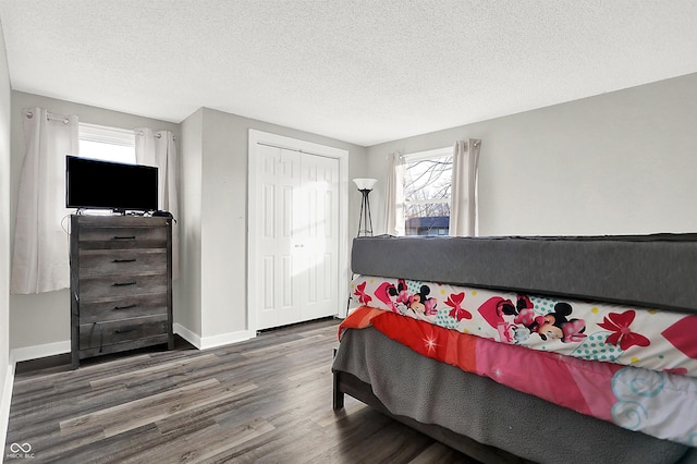 bedroom with hardwood / wood-style floors, a textured ceiling, and a closet