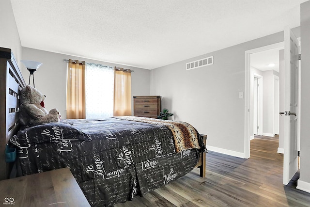 bedroom featuring wood-type flooring and a textured ceiling