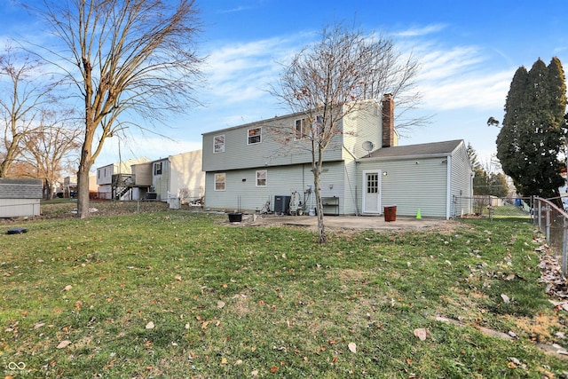 rear view of property featuring a yard, cooling unit, and a patio