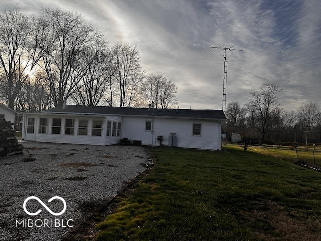 rear view of property featuring a lawn