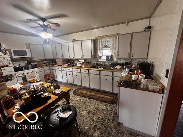 kitchen featuring white cabinets, ceiling fan, sink, and stainless steel range with electric cooktop