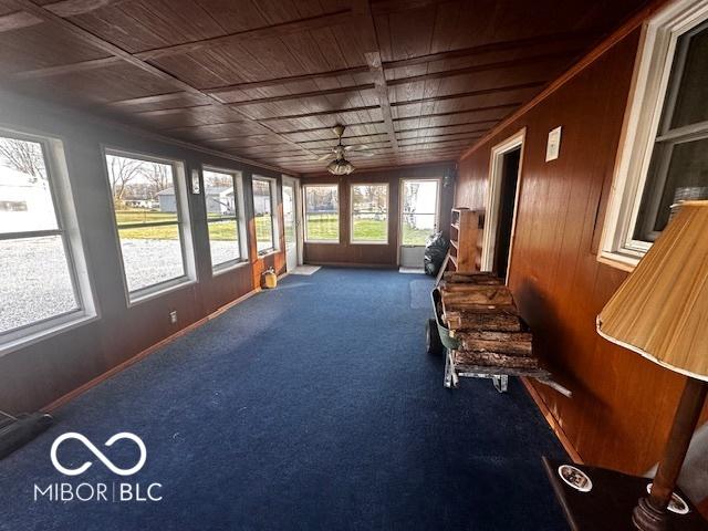 unfurnished sunroom with ceiling fan and wooden ceiling