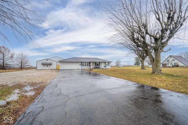 ranch-style house featuring a garage and a front lawn