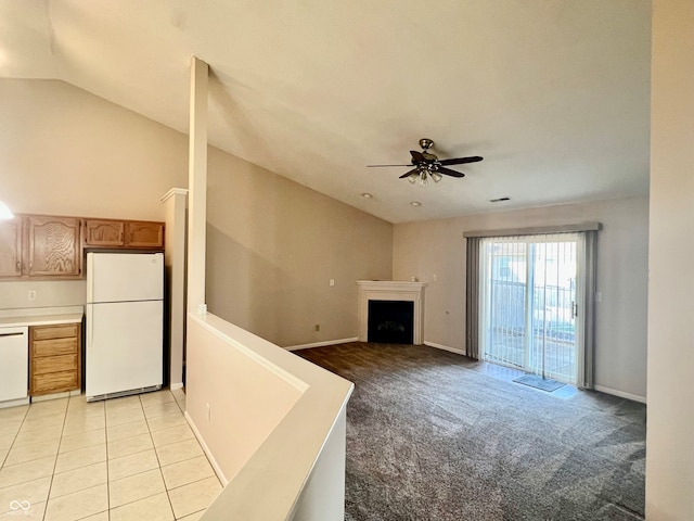 unfurnished living room featuring light colored carpet, ceiling fan, and vaulted ceiling