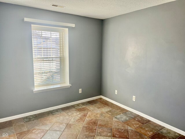 unfurnished room featuring a textured ceiling