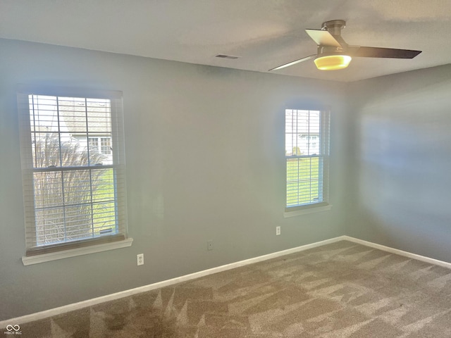 carpeted spare room featuring ceiling fan