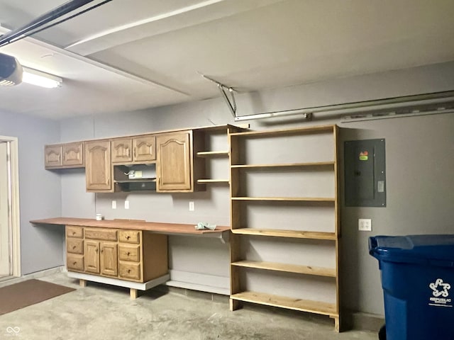 kitchen featuring concrete flooring, electric panel, and light brown cabinets