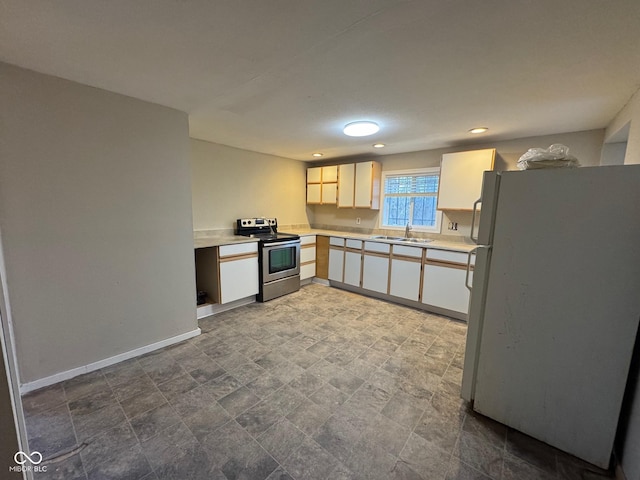 kitchen with white cabinets, sink, white fridge, and electric stove