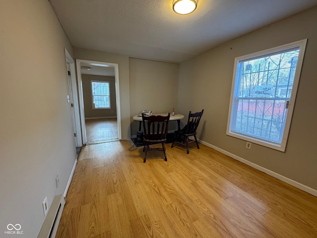 dining area featuring a textured ceiling and light hardwood / wood-style floors