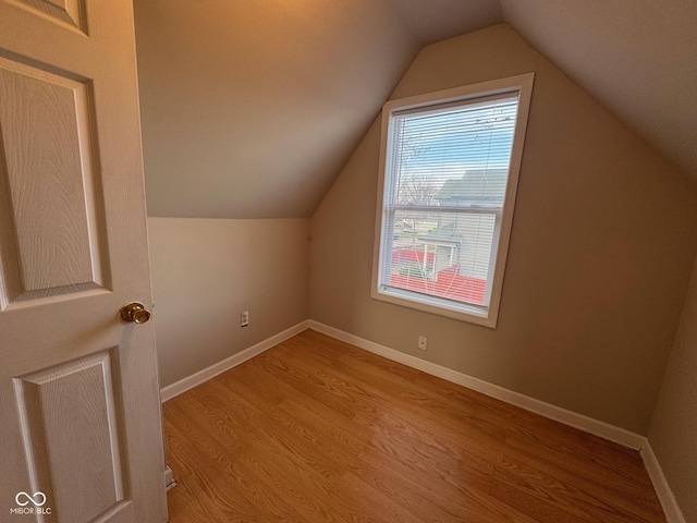 bonus room with vaulted ceiling and light wood-type flooring