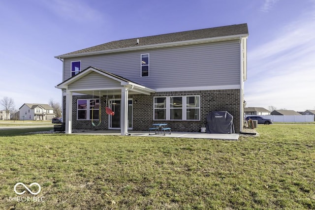 back of house featuring a lawn and a patio