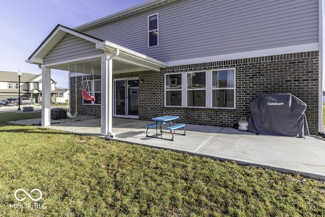 rear view of house with a lawn and a patio