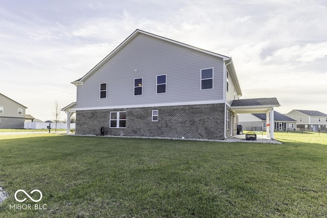 rear view of house with a fire pit and a yard