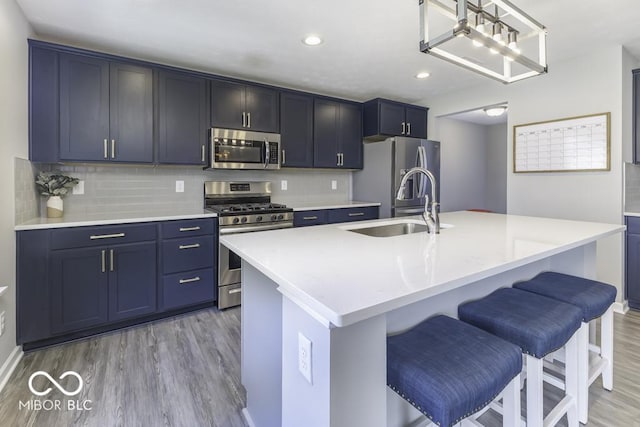 kitchen featuring light hardwood / wood-style floors, sink, a center island with sink, and stainless steel appliances