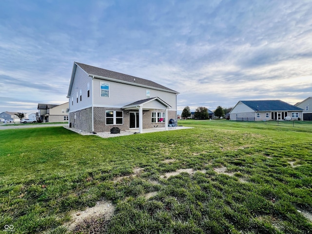 rear view of house featuring a patio area and a yard