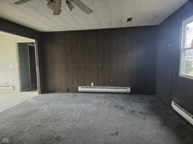 7071 S Charles Pl, Terre Haute, IN 47802 - carpeted empty room with wood walls, a healthy amount of sunlight, and a baseboard heating unit