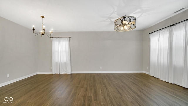 unfurnished room featuring dark hardwood / wood-style flooring and a chandelier