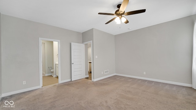 unfurnished bedroom featuring ensuite bathroom, ceiling fan, and light colored carpet