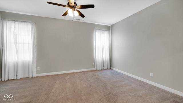 carpeted empty room with ceiling fan and a wealth of natural light