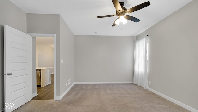 spare room featuring ceiling fan and light colored carpet