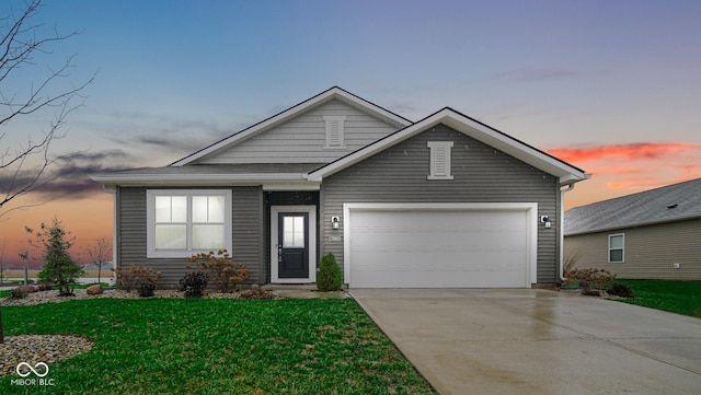 view of front of property with a garage and a yard