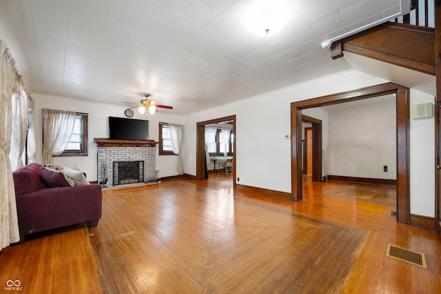 living room featuring hardwood / wood-style flooring, a fireplace, and ceiling fan