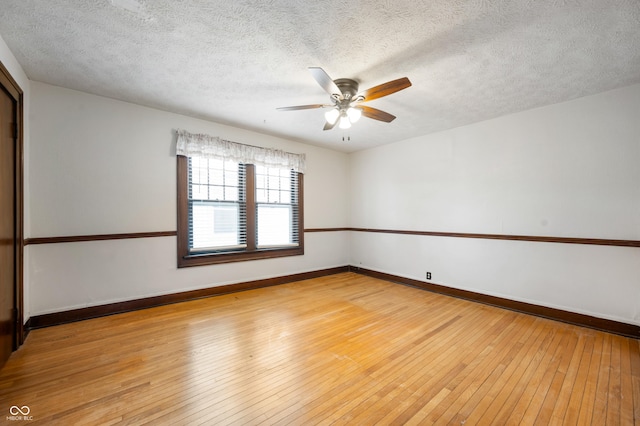 spare room with ceiling fan, light hardwood / wood-style flooring, and a textured ceiling