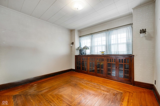 spare room with parquet flooring and ornamental molding