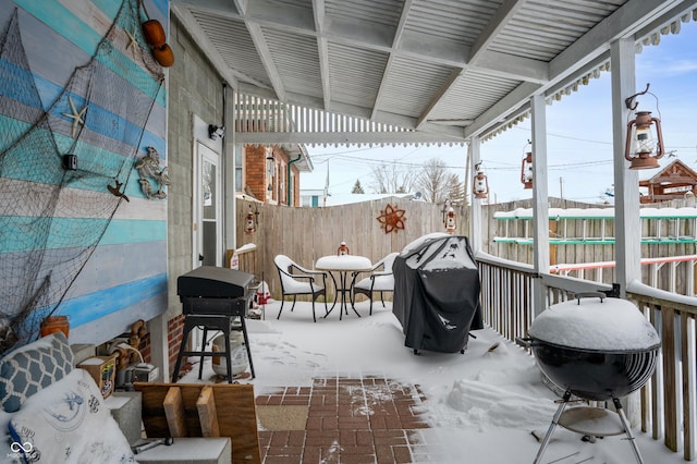 snow covered patio featuring a grill