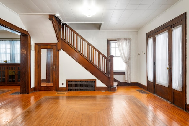 foyer entrance featuring crown molding and light hardwood / wood-style floors