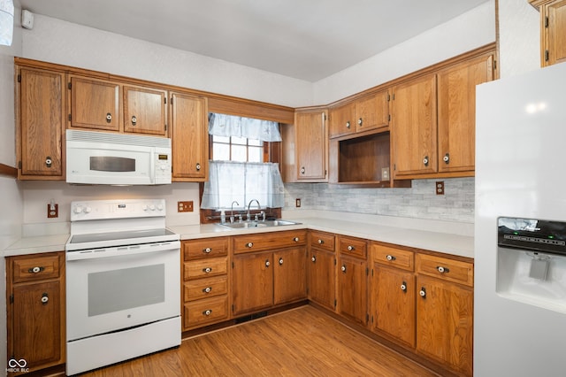 kitchen featuring tasteful backsplash, white appliances, sink, and light wood-type flooring