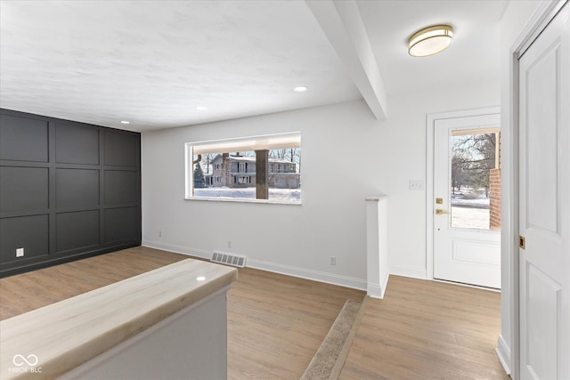 entrance foyer with beamed ceiling and light wood-type flooring