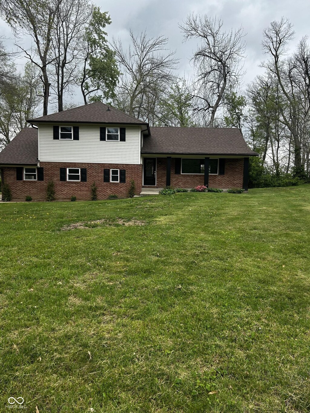 454 Tulip Dr, Mooresville, IN 46158 - split level home featuring a shingled roof, a front lawn, and brick siding