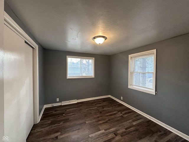 unfurnished bedroom with dark hardwood / wood-style floors and a closet