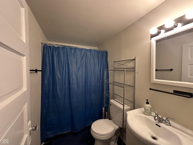 bathroom featuring a shower with curtain, toilet, and sink