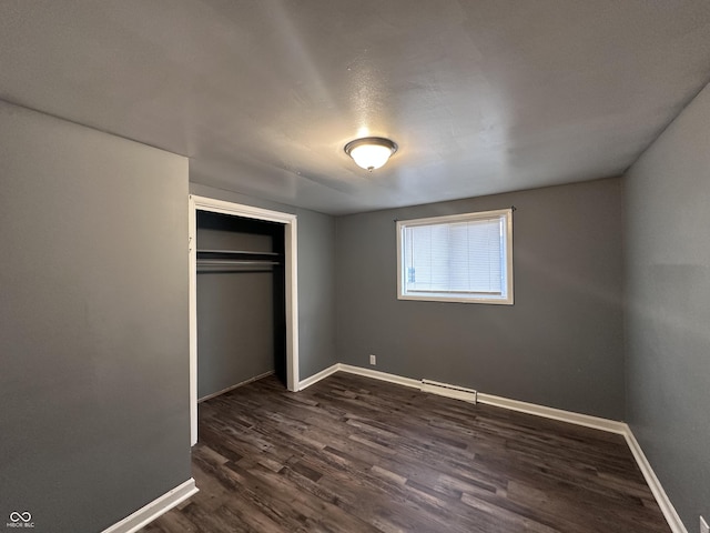 unfurnished bedroom with dark wood-type flooring and a closet