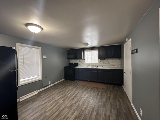 kitchen featuring dark hardwood / wood-style flooring, sink, tasteful backsplash, and black appliances