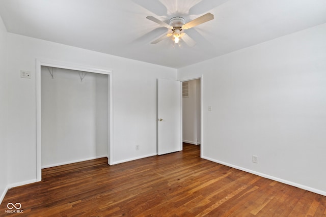 unfurnished bedroom featuring a closet, wood finished floors, a ceiling fan, and baseboards