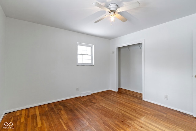 unfurnished bedroom featuring a closet, wood-type flooring, visible vents, and baseboards