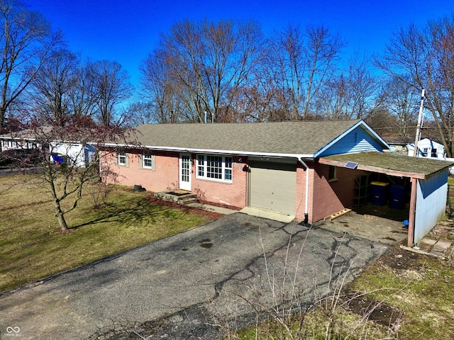 view of front of home featuring a front lawn, driveway, roof with shingles, an attached garage, and brick siding