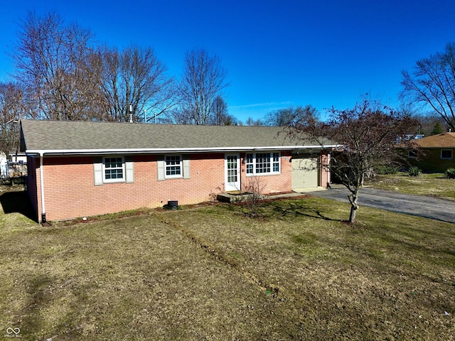 ranch-style home featuring a shingled roof, a front lawn, a garage, aphalt driveway, and brick siding